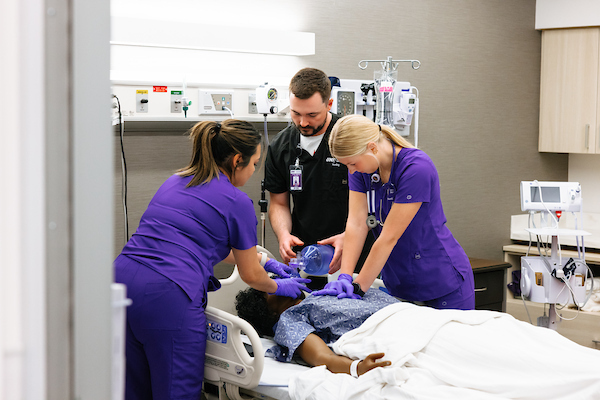 Nursing students giving CPR to simulation dummy