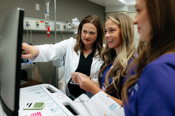 Nursing students working with a faculty member