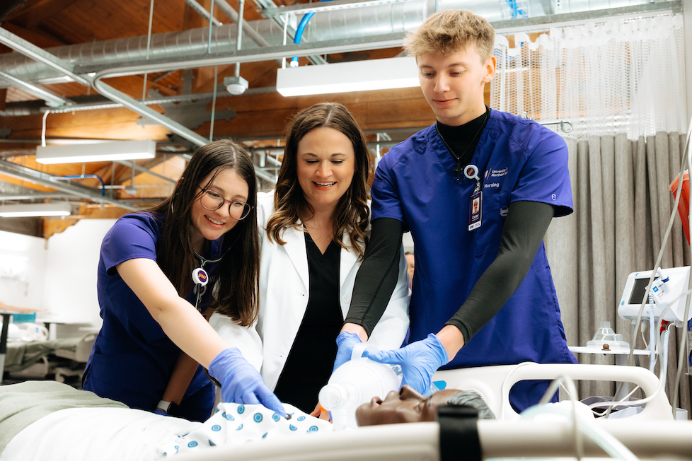 Nursing students working on a lab dummy