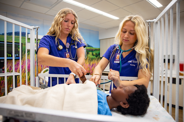 Nursing students working on infant simulation dummy
