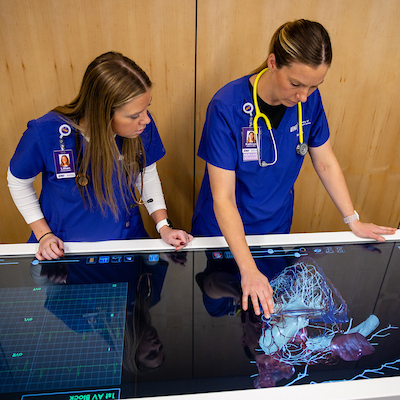 Nursing students looking at simulation technology